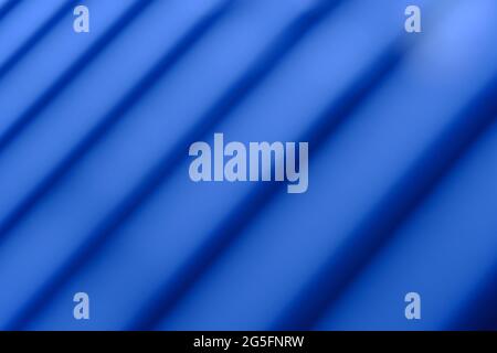 Abstrakte Makrofotografie. Weiche, unscharfe Metallstruktur, Hintergrund mit Linienmuster und blauem Licht Stockfoto