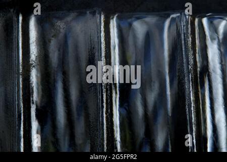 Abstrakte Makrofotografie. Beleuchtete schwarz-weiße Glaslampe Textur, verschwommener Hintergrund Stockfoto