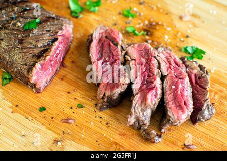 Tequila Lime mariniertes Hanger Steak: Seltenes Metzgersteak auf einem Bambusschneidebrett Stockfoto