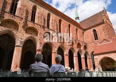 Chorin, Deutschland. Juni 2021. Gäste hören ein Konzert des Mendelssohn Kammerorchesters Leipzig beim 58. Chormusiksommer im Kloster Chorin. Aufgrund der Corona-Pandemie dürfen Besucher in diesem Jahr nur auf Stühlen sitzen, um den Mindestabstand einzuhalten. Es werden nur 500 von 1200 Plätzen angeboten. Das erste Konzert fand am 23. Mai 1964 als Kulturveranstaltung des Instituts für Waldwissenschaften in Eberswalde statt.000 Gäste jährlich. Quelle: dpa picture Alliance/Alamy Live News Stockfoto