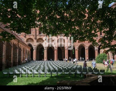 Chorin, Deutschland. Juni 2021. Besucher kommen zum 58. Chorin Music Summer ins Kloster Chorin mit einem Konzert des Mendelssohn Kammerorchesters Leipzig. Aufgrund der Corona-Pandemie dürfen Besucher in diesem Jahr nur auf Stühlen sitzen, um den Mindestabstand einzuhalten. Es werden nur 500 von 1200 Plätzen angeboten. Das erste Konzert fand am 23. Mai 1964 als Kulturveranstaltung des Instituts für Waldwissenschaften in Eberswalde statt.000 Gäste jährlich Quelle: dpa picture Alliance/Alamy Live News Stockfoto