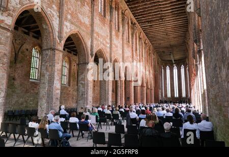 Chorin, Deutschland. Juni 2021. Gäste hören ein Konzert des Mendelssohn Kammerorchesters Leipzig beim 58. Chormusiksommer im Kloster Chorin. Aufgrund der Corona-Pandemie dürfen Besucher in diesem Jahr nur auf Stühlen sitzen, um den Mindestabstand einzuhalten. Es werden nur 500 von 1200 Plätzen angeboten. Das erste Konzert fand am 23. Mai 1964 als Kulturveranstaltung des Instituts für Waldwissenschaften in Eberswalde statt.000 Gäste jährlich. Quelle: dpa picture Alliance/Alamy Live News Stockfoto