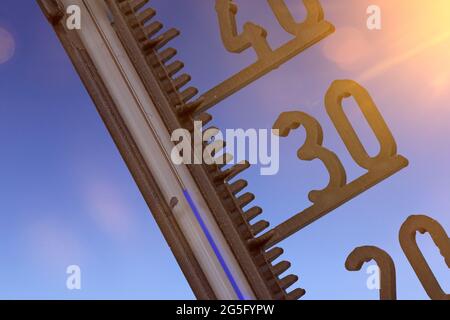 Symbolbild: Thermometer vor blauem Himmel zeigt warme Temperaturen Stockfoto