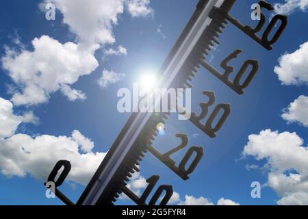 Symbolbild: Thermometer vor blauem Himmel zeigt warme Temperaturen Stockfoto