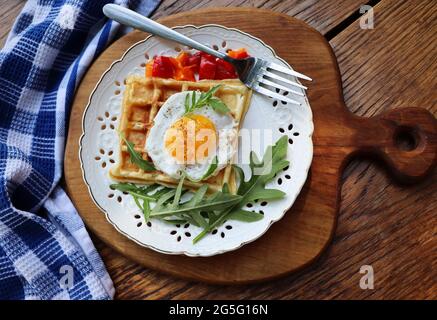 Gesundes Frühstück. Frisch zubereitete, köstliche Mahlzeit mit Eiern und Gemüse. Glutenfreie Buchweizenwaffeln mit Spiegeleiern Stockfoto