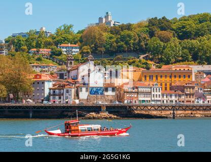 Porto, Bezirk Porto, Portugal. Blick über den Douro-Fluss von Vila Nova de Gaia zum Ribeira-Viertel. Boote wie dieses, mit Touristen, die eine Reise genießen Stockfoto