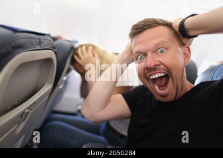 Mann, der im Flugzeug fliegt und vor Angst schreit Stockfoto