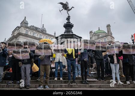 London, Großbritannien. Juni 2021. Apple Daily protestiert am Piccadilly Circus. Journalisten und Anhänger von Hongkongs größtem prodemokratischen Nachrichtengeschäft halten britische Zeitungen in die Hand, um gegen die erzwungene Schließung und das Einfrieren von Vermögenswerten der 26-jährigen Boulevardzeitung zu protestieren. Die letzte Ausgabe der Apple Daily wurde am 24. Donnerstag veröffentlicht, wobei die Hongkonger Behörden fünf Redakteure und Führungskräfte verhafteten. Kredit: Guy Corbishley/Alamy Live Nachrichten Stockfoto