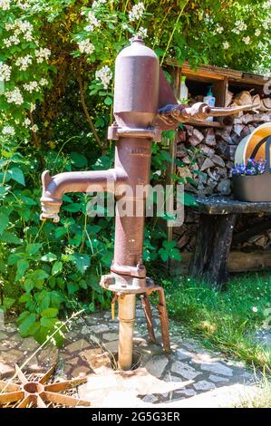 Alte, aber noch funktionsfähige Handpumpe zum Transport des Grundwassers nach oben. Stockfoto