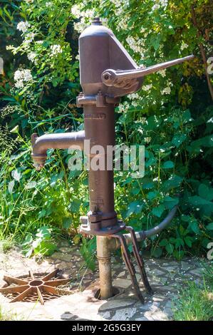 Alte, aber noch funktionsfähige Handpumpe zum Transport des Grundwassers nach oben. Stockfoto