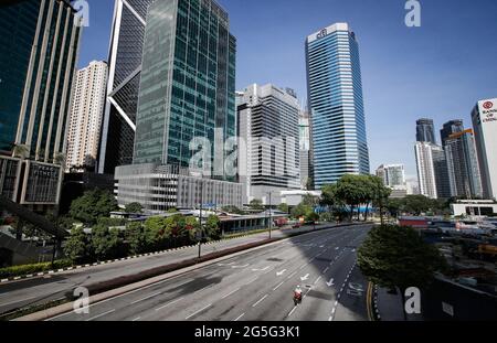 Kuala Lumpur, Malaysia. Juni 2021. Ein Motorradfahrer fährt auf leeren Straßen in der Innenstadt von Kuala Lumpur. Die malaysische Regierung kündigte an, dass die am Montag fällige, einmonatige Vollsperrung aufgrund der täglich hohen Zahl der gemeldeten Fälle von Coronavirus-Infektionen verlängert wird. Kredit: SOPA Images Limited/Alamy Live Nachrichten Stockfoto