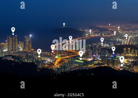 Karte von Pin-Symbolen auf Busans Skyline bei Sonnenuntergang. Malerische Stadtansicht der städtischen Skyline von Busan in Südkorea von oben bei Nacht. Stockfoto