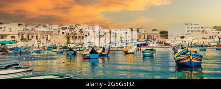 Panoramablick auf den Dorfhafen von Malta, beleuchtet von Sonnenuntergang Stockfoto