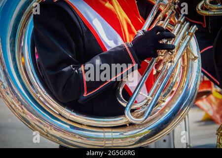 Sousafon umkreist uniformierte Studenten marschieren Schulter, während er das Instrument in einer Parade spielt - Nahaufnahme Stockfoto