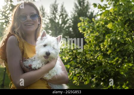 Nettes kleines Mädchen umarmt goldenen Retriever mit Liebe Augen geschlossen, lächelnd. Stockfoto