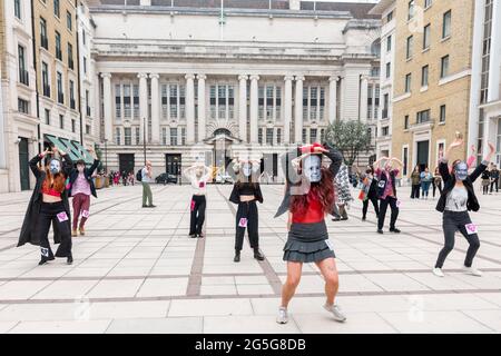 London, Großbritannien. Juni 2021. Extinction Rebellion Demonstranten, die die Gesichtsmaske von Milliardären tragen, die beschuldigt werden, Desinformationen in britischen Zeitungen zu verbreiten, führen in Waterloo einen Flash-Mob-Tanz durch.Extinction Rebellion-Aktivisten versammelten sich am Parliament Square, um das Massensterben zu halbieren und das Risiko eines sozialen Zusammenbruchs zu minimieren. Insbesondere zielt dieser Protest darauf ab, das Bewusstsein der britischen Bevölkerung für das Schweigen der Medien und die Manipulation von Informationen durch die vier Milliardäre, die die großen britischen Zeitungen kontrollieren, zu erhöhen. Kredit: SOPA Images Limited/Alamy Live Nachrichten Stockfoto