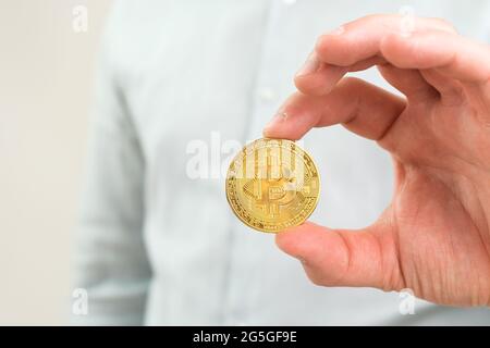 Nahaufnahme Goldmünze in Mans Hand. Stockfoto