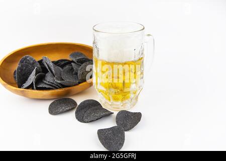 Bierhintergrund. Frisches Bier und Kartoffelchips auf einem Holzteller. Freier Speicherplatz für Text Stockfoto