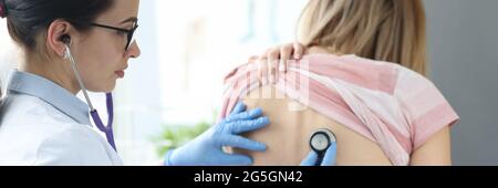 Arzt Therapeut Hören auf die Lungen des Patienten von hinten Stockfoto