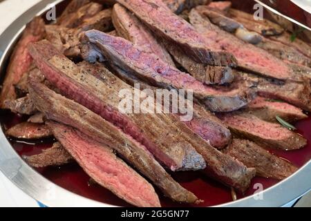 Blutiges rotes Fleisch auf einem Tablett serviert. Stockfoto