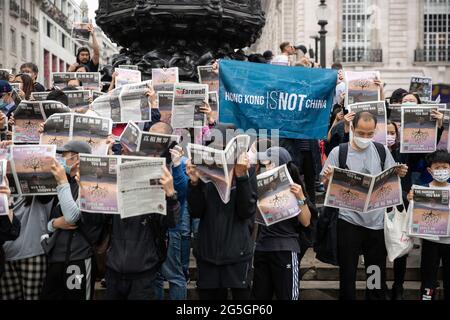 London, Großbritannien. Juni 2021. Anhänger halten eine Flagge mit der Aufschrift Hongkong ist nicht China und die Sonderausgabe, während der Solidaritätsdemonstration mit Apple Daily. Jeffery Tam, ehemaliger Mitarbeiter der Apple Daily in London, produzierte zusammen mit einer Gruppe von Medienmitarbeitern eine Sonderausgabe als Reaktion auf den Tod der Apple Daily in Hongkong. Sie hielten eine Versammlung ab, gaben kostenlose Exemplare der Sonderausgabe der Apple Daily Zeitung heraus und erklärten den Einheimischen, was mit der Pro-Demokratie-Zeitung in Hongkong geschehen war. (Foto von May James/SOPA Images/Sipa USA) Quelle: SIPA USA/Alamy Live News Stockfoto