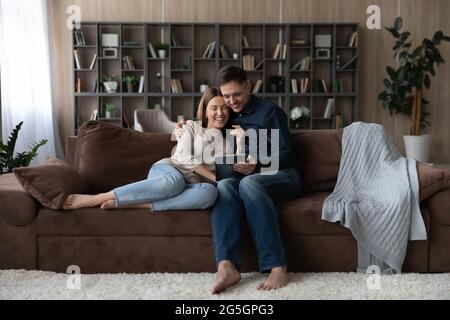 Glückliches Paar Entspannen Sie sich zu Hause mit einem Tablet zusammen Stockfoto