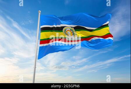 Minsk, Weißrussland - Mai, 2021: Flagge der Ostafrikanischen Gemeinschaft winkt im Wind am Fahnenmast auf dem Hintergrund des blauen Himmels. 3d-Illustration. Stockfoto