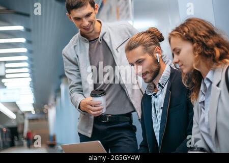 Junge Geschäftsleute mit einem Laptop auf dem U-Bahnsteig. Stockfoto