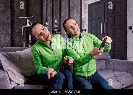 Reife Frauen spielen Videospiele in Loft-Wohnung. Stockfoto