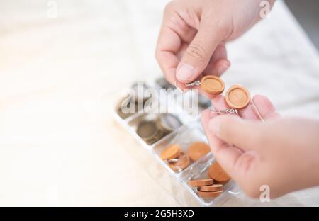 Die weiblichen Hände halten und die Wahl der Holzplatte Rahmen Ohrring für Stickgarn, für Handwerk und Hobby-Konzept. Stockfoto