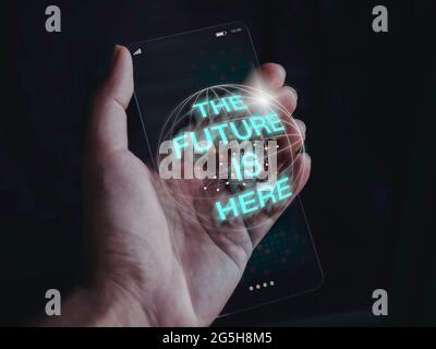 Futuristisches modernes, transparentes Glas-Telefontechnologiekonzept. Die Zukunft ist da, 3d-Text auf die Zukunft schlank transparent Smartphone in der Hand auf dunkel zu Stockfoto