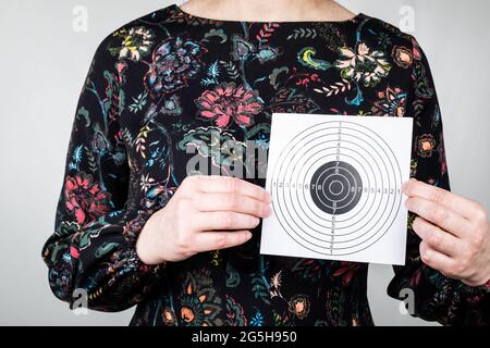 Papierzielscheibe in Frauenhand. Symbolisiert Leistung, Gesundheit oder Zukunftspläne. Stockfoto