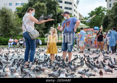 Barcelona, Spanien. Juni 2021. Touristen füttern Tauben auf dem Katalonienplatz in Barcelona, Spanien, 26. Juni 2021. UM MIT "Spaniens größten Städten zu GEHEN, starten Kampagnen, um int'l Besucher zurück zu locken" Credit: Zhang Cheng/Xinhua/Alamy Live News Stockfoto