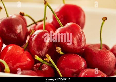 Frische Kirschen auf weißem Teller, fertig zum Essen Stockfoto