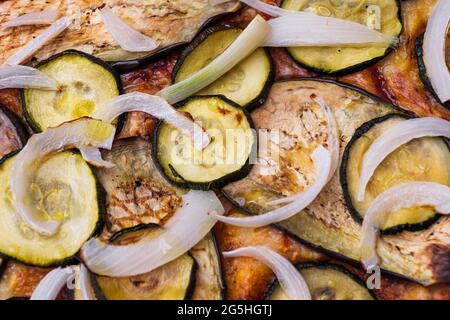 Nahaufnahme der Pizza mit gegrillter Aubergine, Zucchini und Zwiebeln. Makroaufnahme köstlicher Produkte. Stockfoto