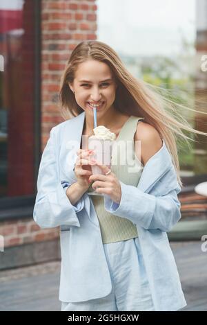 Eine Frauenhand hält einen erfrischenden Cocktail in einem Glas mit einer Tube. Stockfoto