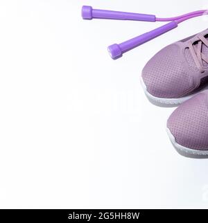 Lila Springseil, Sneakers auf weißem Hintergrund. Banner mit Platz für Text. Seitenansicht. Selektiver Fokus. Stockfoto