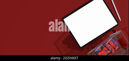 Draufsicht auf ein digitales Tablet mit nachgebildeten Bildschirmen, Karren und Geschenkboxen auf rotem Hintergrund, 3D-Rendering, 3D-Illustration Stockfoto
