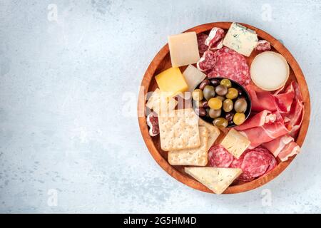 Fleisch- und Käseplatte, von oben mit Kopierplatz aufgenommen. Schinken aus Parmaschinken, Blauschimmelkäse, Oliven und Cracker. Gourmet-Antipasti Stockfoto