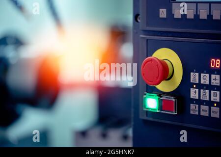 Rote Taste des Bedienfelds CNC-Alarm auf der automatischen Metallbearbeitungsmaschine, Konzept der Einhaltung der Sicherheit und Arbeitsschutz. Stockfoto