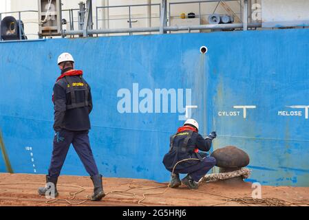 Zwei Hafenarbeiter, die ein Frachtschiff im Hafen von Bilbao, Biskaya, Baskenland, Euskadi, Spanien, Europa Stockfoto