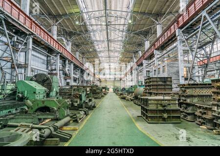 Metallbearbeitungsmaschinen in großer Werkstatt. Schwerindustrie. Metallurgische Anlage. Industrieller Innenraum. Stockfoto