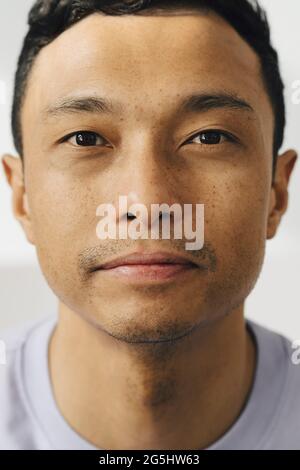 Porträt eines Mannes mit Haarstoppel an der weißen Wand Stockfoto