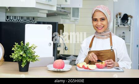 Muslimische Frau Trägt Hijab Trägt Schürze In Der Küche Stockfoto