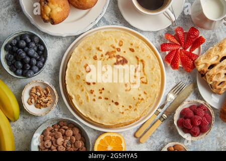 Frühstück mit frischen Früchten, Pfannkuchen, Kaffee, Croissants Stockfoto