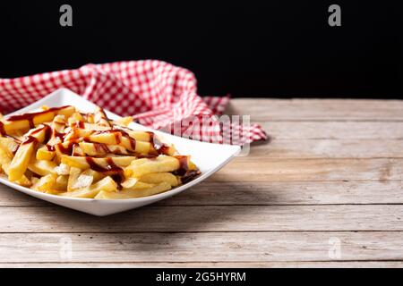 Traditionelles kanadisches Poutine auf Holztisch Stockfoto