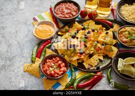 Mexikanische Nachos Tortilla Chips mit schwarzen Bohnen, Jalapeno, Guacamole Stockfoto