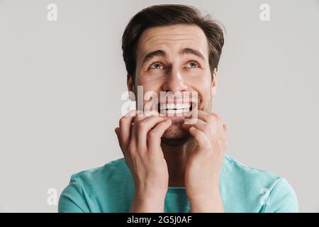 Nahaufnahme eines erschrockenen schockierten, betäubt männlichen Mannes, isoliert auf grauem Hintergrund, der nach oben schaute Stockfoto