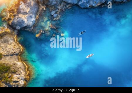 Luftaufnahme von Menschen auf schwimmenden Schautafeln auf blauem Meer Stockfoto