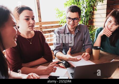 Junge Leute arbeiten zusammen an einem Projekt in einem alternativen Büro - Geschäftsleute machen Brainstorming und Startup zusammen-Geschäftsmann hält einen m Stockfoto